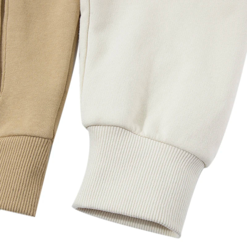 Close-up of beige and white cuffs of women's Puma track jacket showing ribbed knit detail