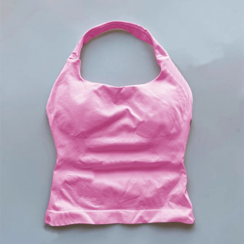 Pink seamless backless sports tank top with halter neck design laid flat