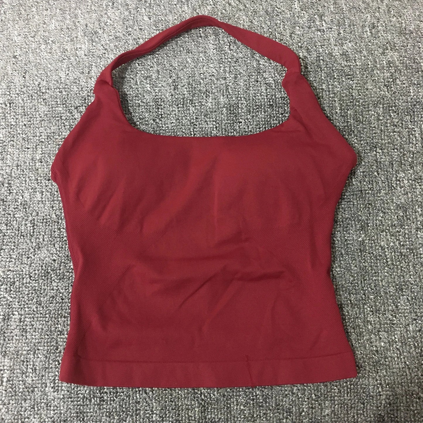 KiKis seamless backless sports tank top in deep red laid flat on gray carpet