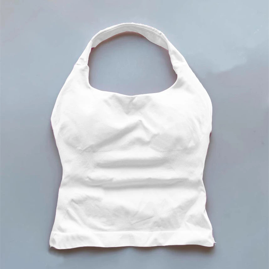 White seamless backless sports tank top laid flat on gray background by KiKis