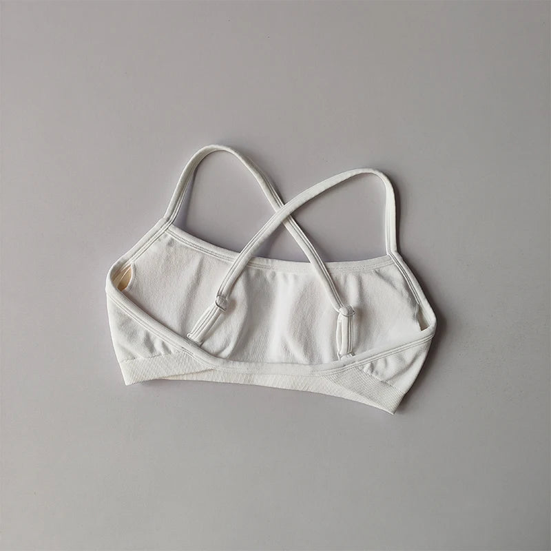 KiKis white seamless yoga suit for women with adjustable crisscross straps laid flat