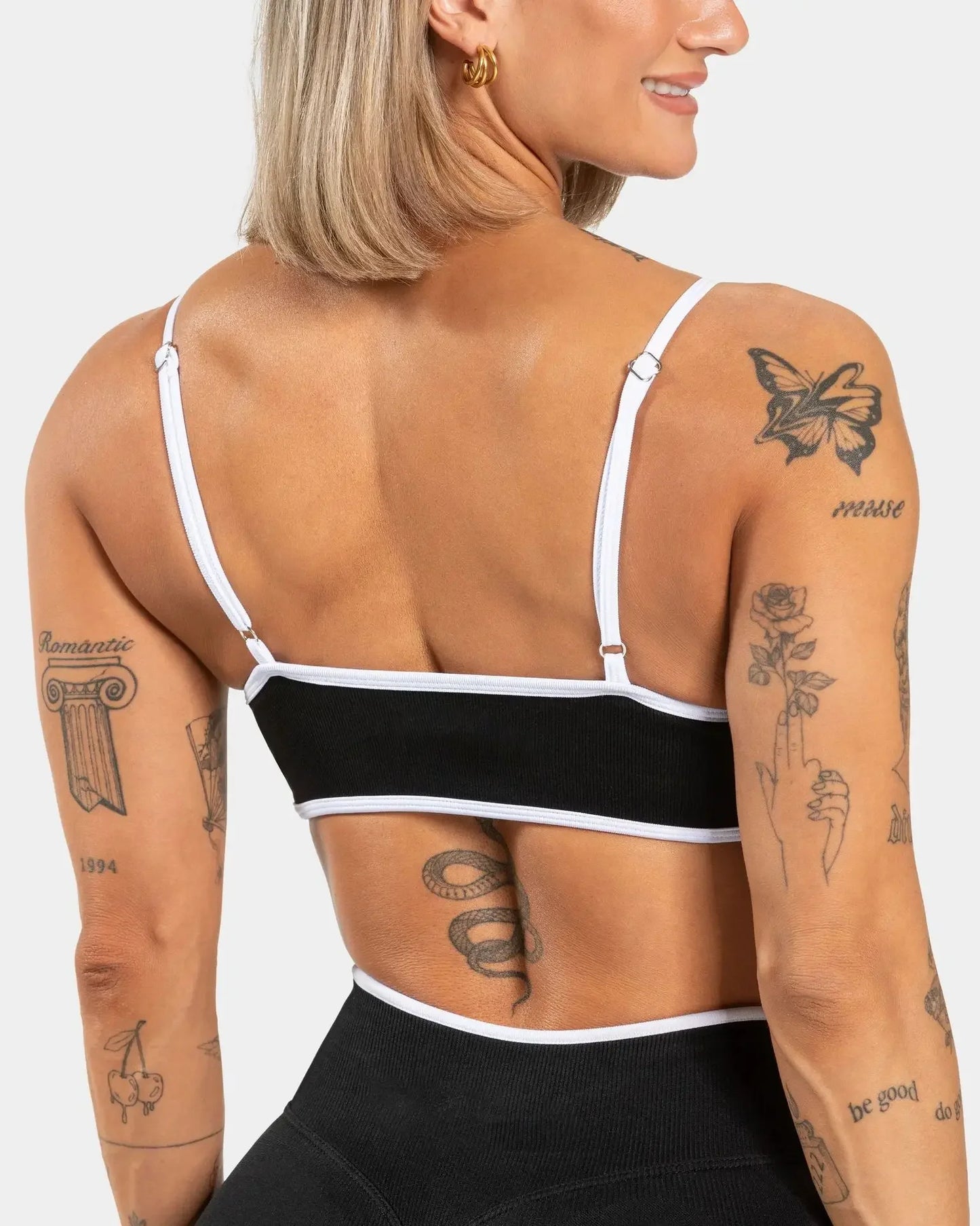 KiKis shockproof yoga bra outdoor fitness in black with white trim worn by woman from back