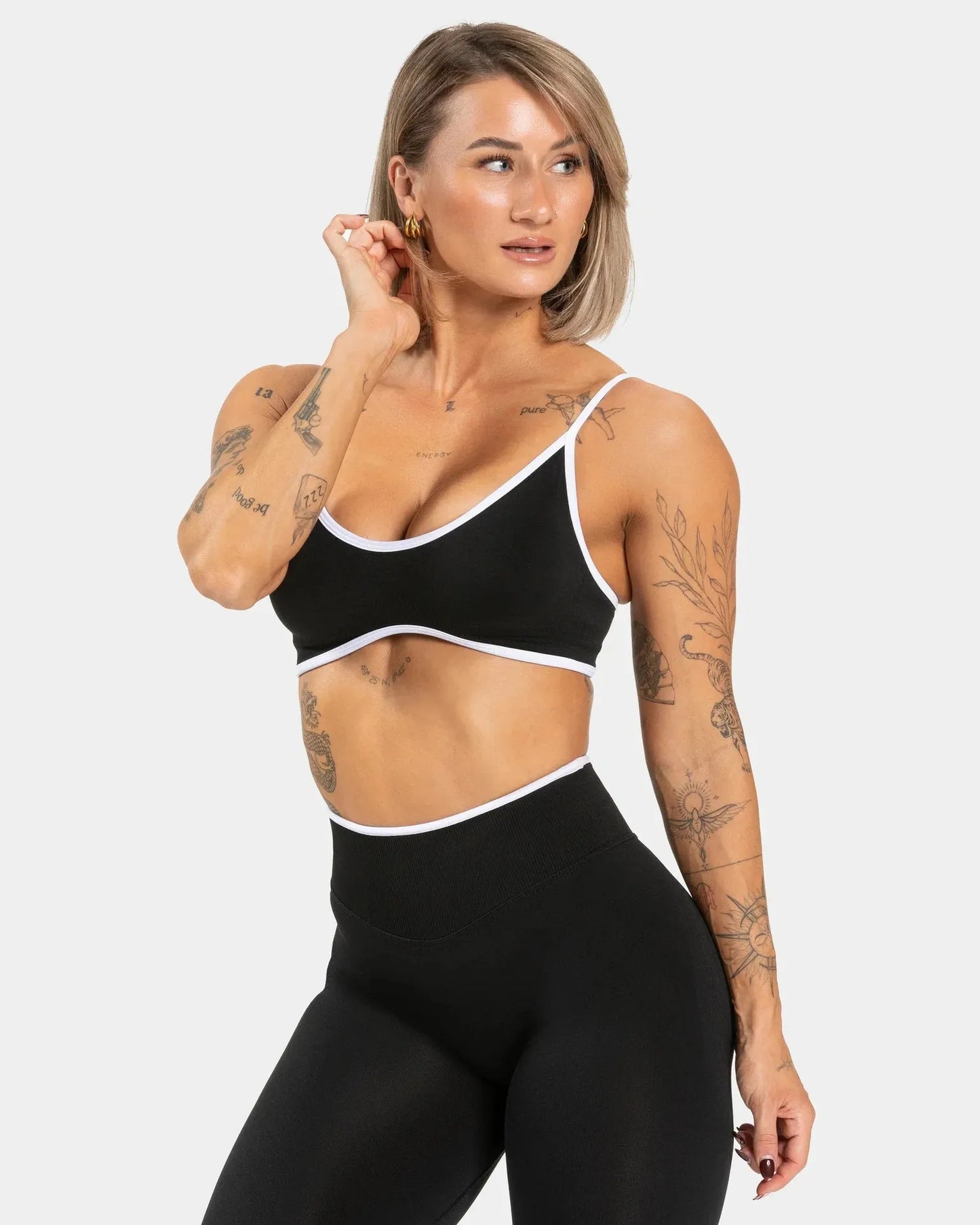 KiKis shockproof yoga bra outdoor fitness black with white trim worn by tattooed model