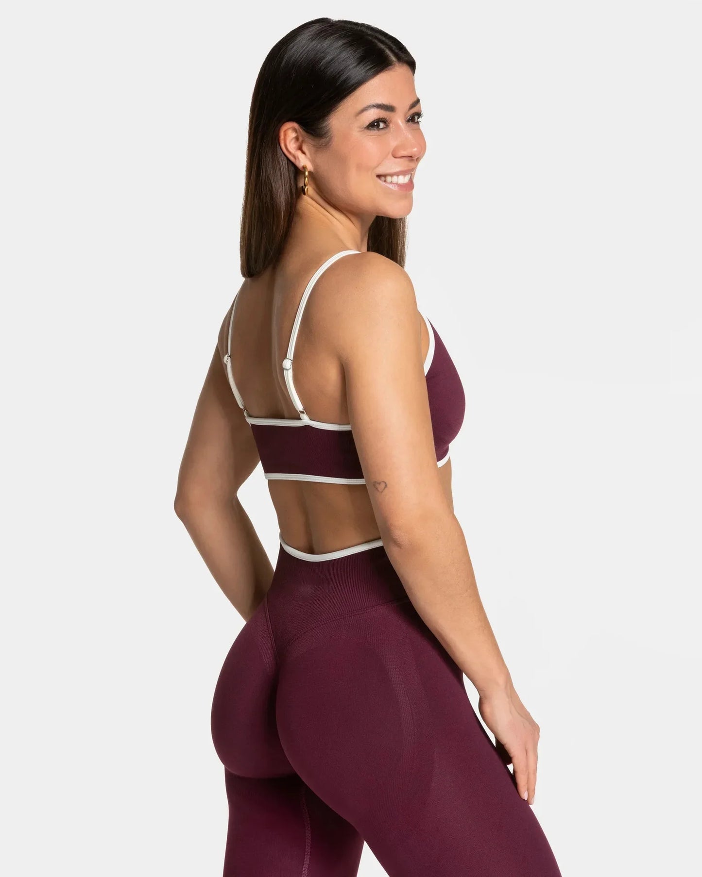 KiKis shockproof yoga bra outdoor fitness in burgundy with white straps worn by smiling woman