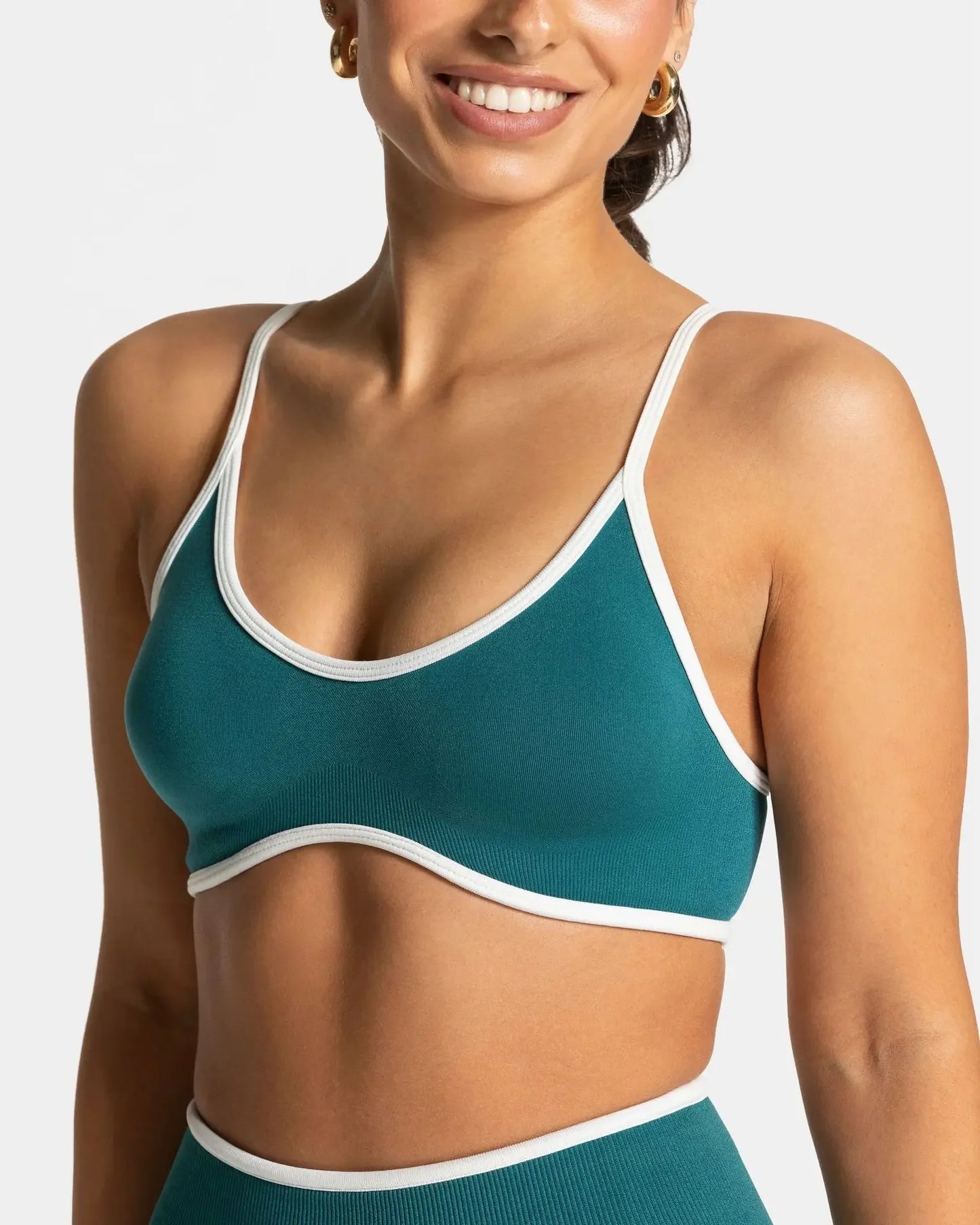 KiKis shockproof yoga bra outdoor fitness in teal with white trim on smiling woman