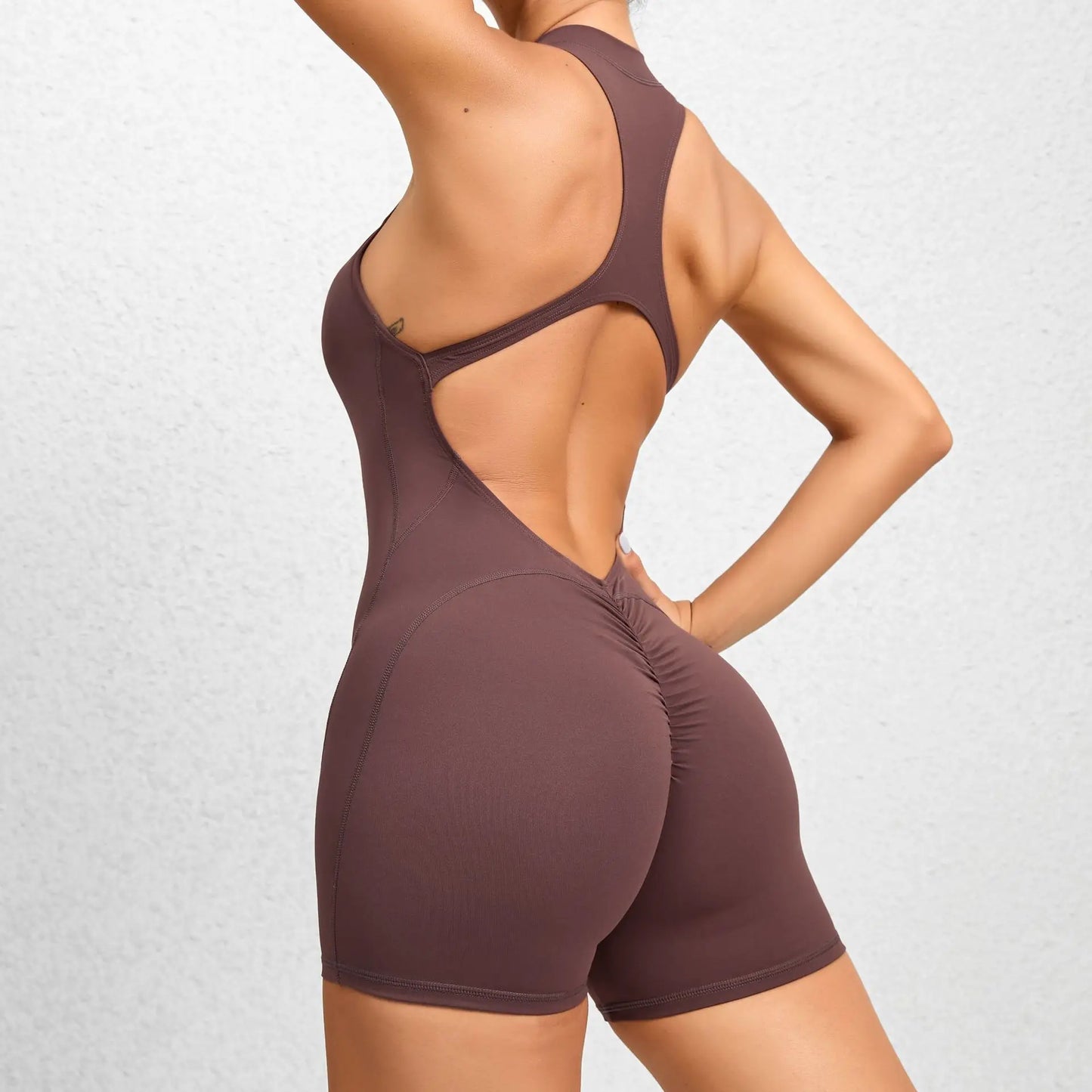 KiKis sleeveless workout romper in brown with open back and ruched shorts detail