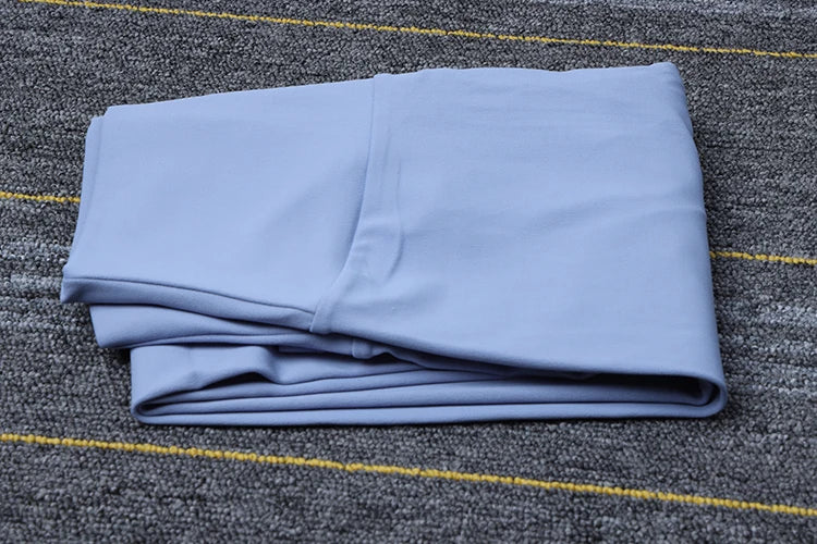 Light blue folded Womens Seamless Yoga pants by SOISOU on textured gray surface with yellow stripes