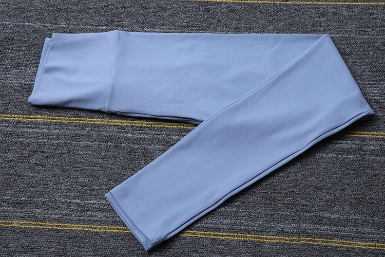 Light blue Womens Seamless Yoga pants by SOISOU laid flat on a grey carpet background
