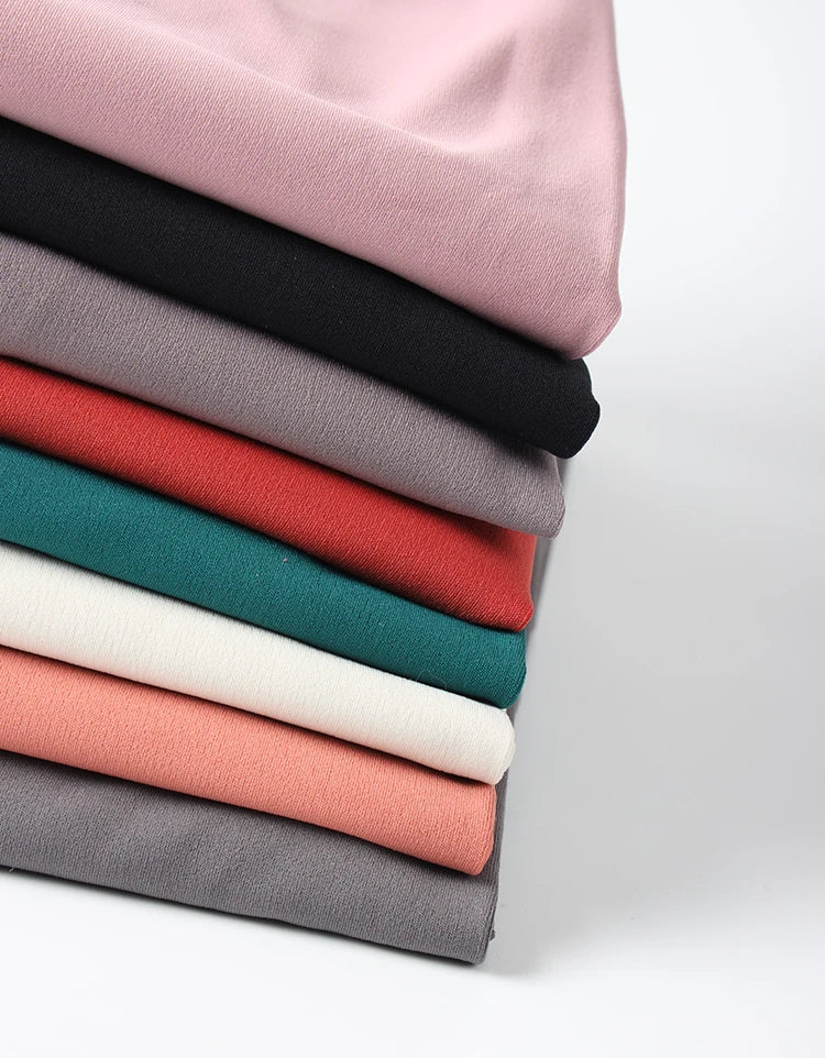 Stack of colorful Womens Seamless Yoga pants by SOISOU neatly folded in various shades
