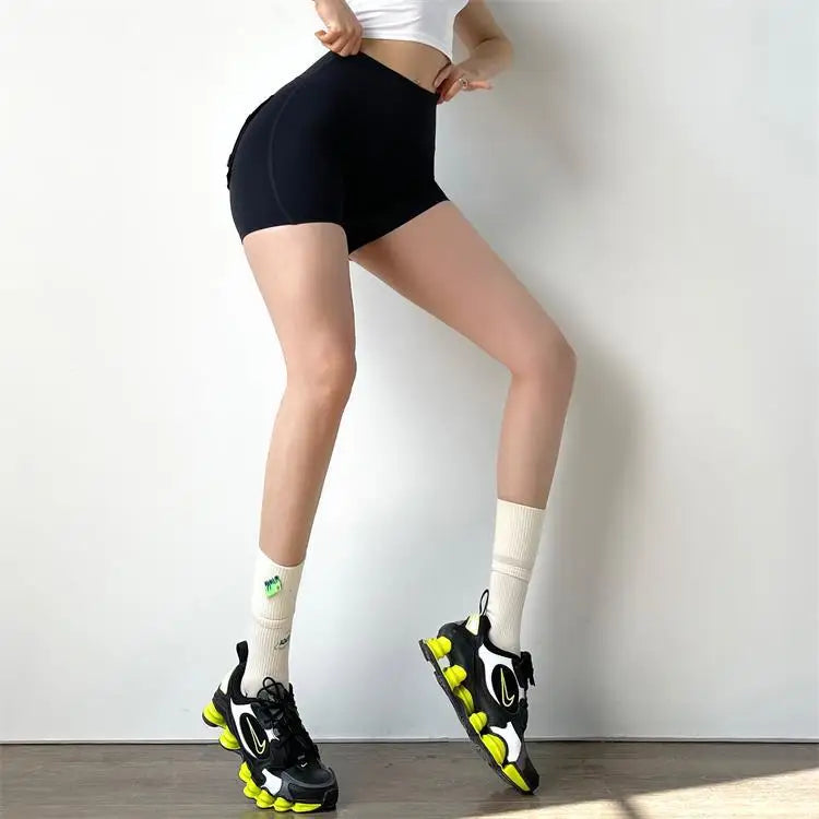 KiKis black high waisted cycling shorts women modeled with white crop top and black sneakers