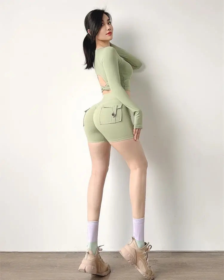 Woman wearing light green high waisted cycling shorts women with side pockets and matching long sleeve top