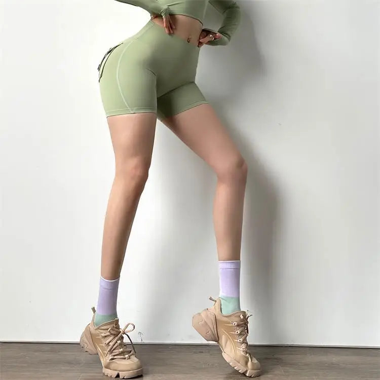 KiKis high waisted cycling shorts women in light green modeled with matching top and beige sneakers