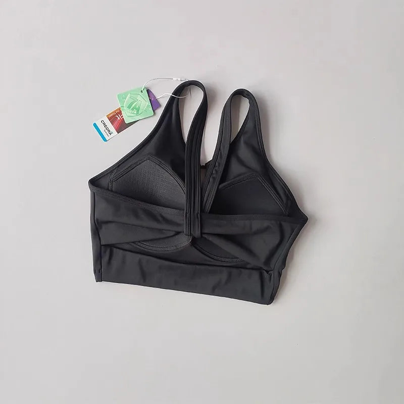 KiKis black women's push up sports bra with adjustable straps and tag on gray background