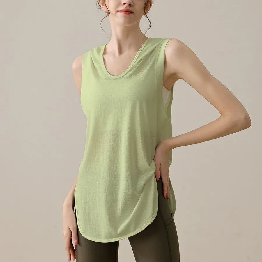 KiKis light green summer sleeveless workout hoodie worn by woman with brown leggings