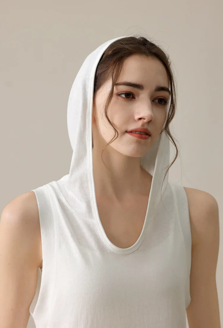 KiKis white summer sleeveless workout hoodie worn by woman with hood up and sleeveless design