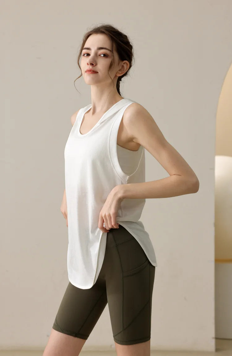 KiKis white summer sleeveless workout hoodie worn with olive green biker shorts