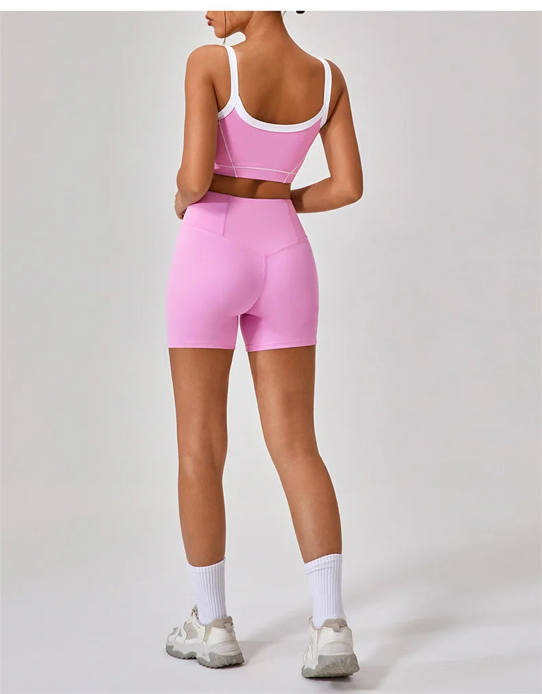 Back view of woman wearing women's nude fitness shorts set in pink with white crop top and sneakers
