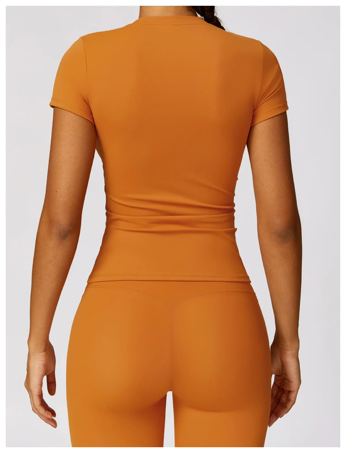 KiKis seamless yoga top for women in burnt orange color shown from the back with short sleeves