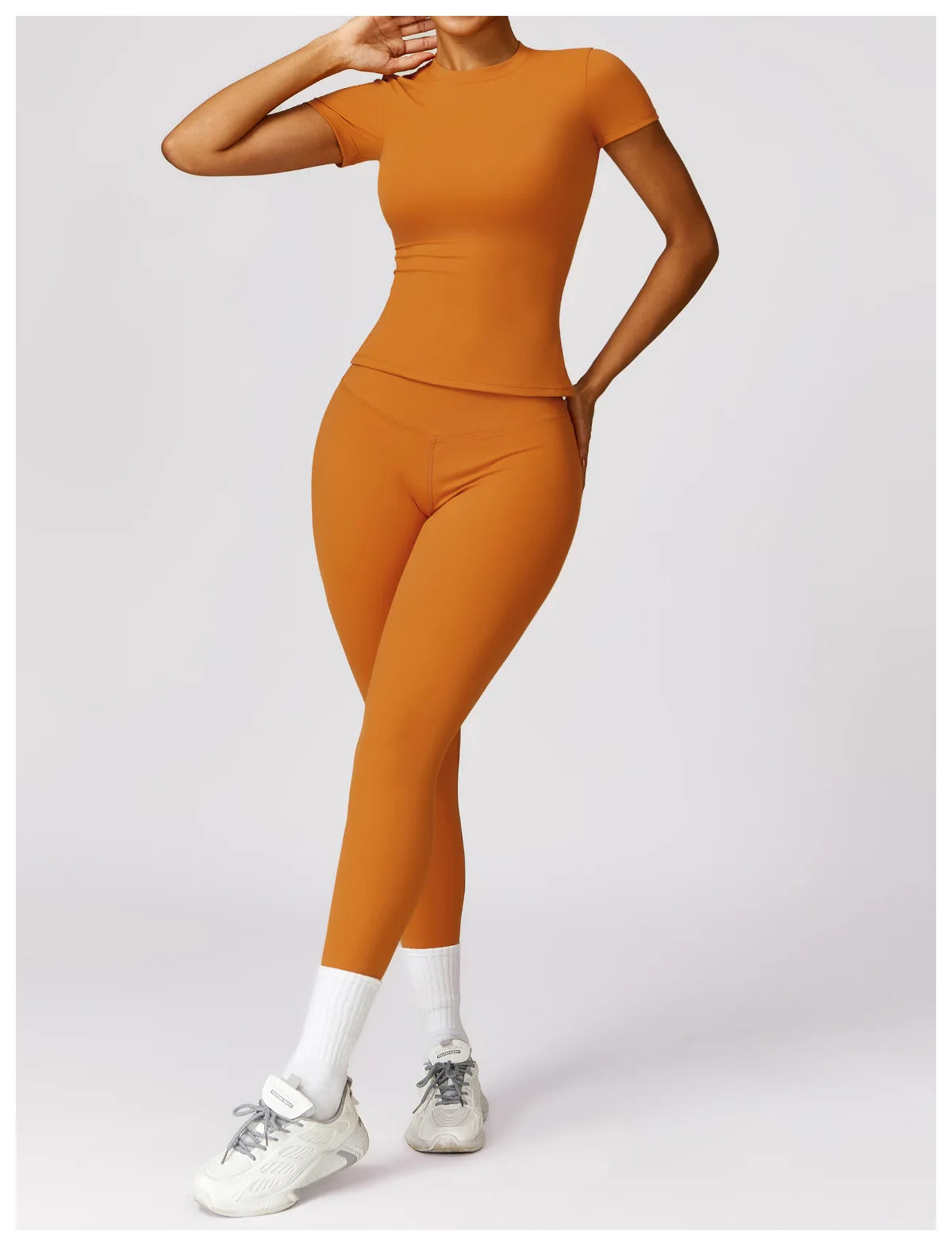 KiKis seamless yoga top for women in orange with matching leggings and white sneakers