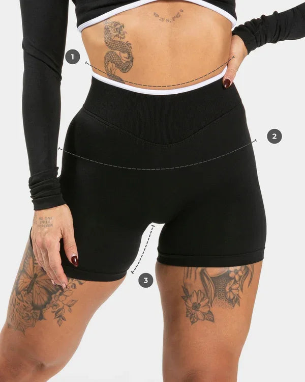 KiKis women's seamless high waist gym shorts in black worn by tattooed model with long sleeve crop top