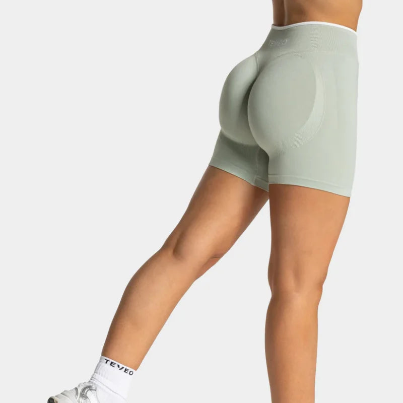 KiKis women's seamless high waist gym shorts in light gray shown from the back on a female model