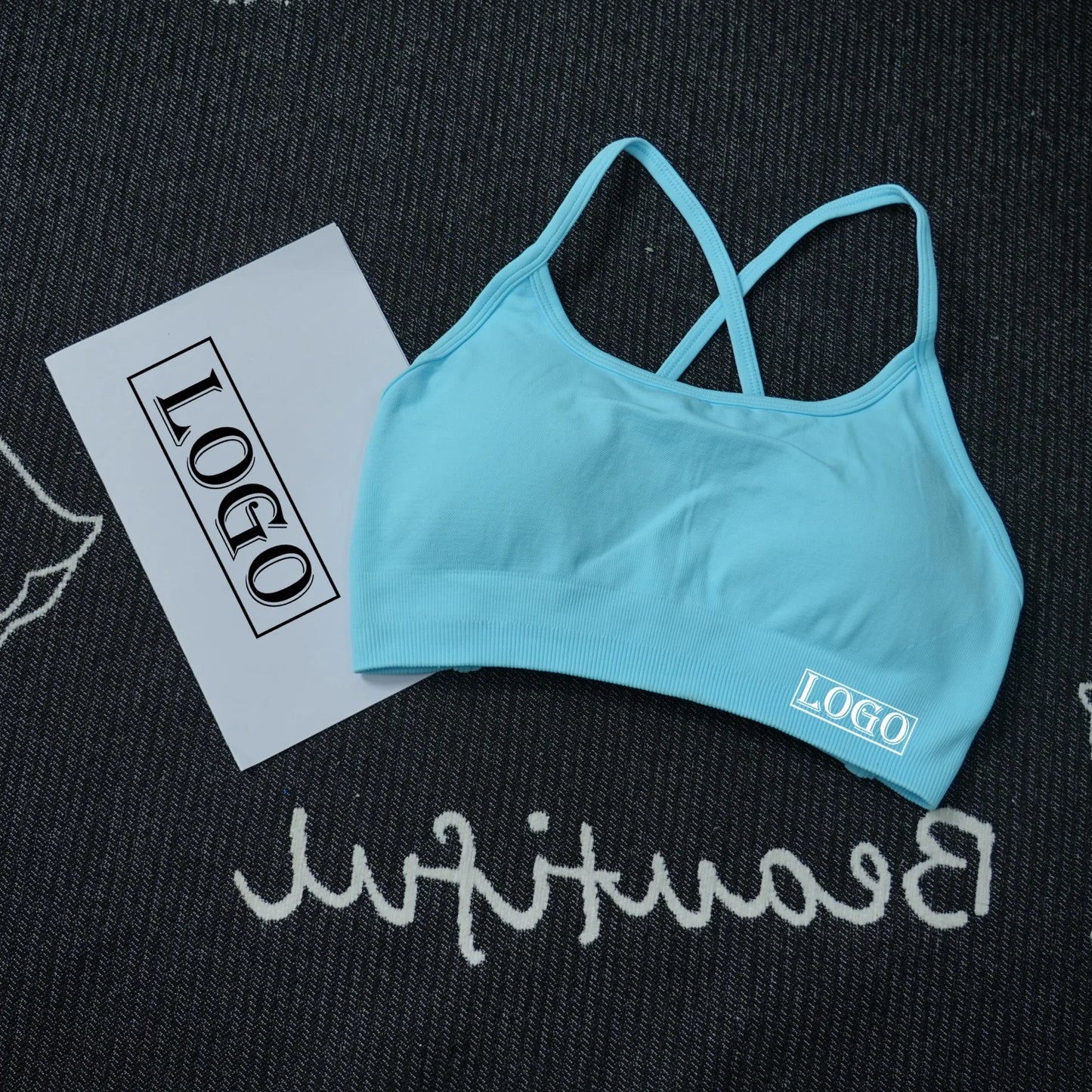 KiKis blue women's seamless sports bra with crisscross back straps on black fabric background