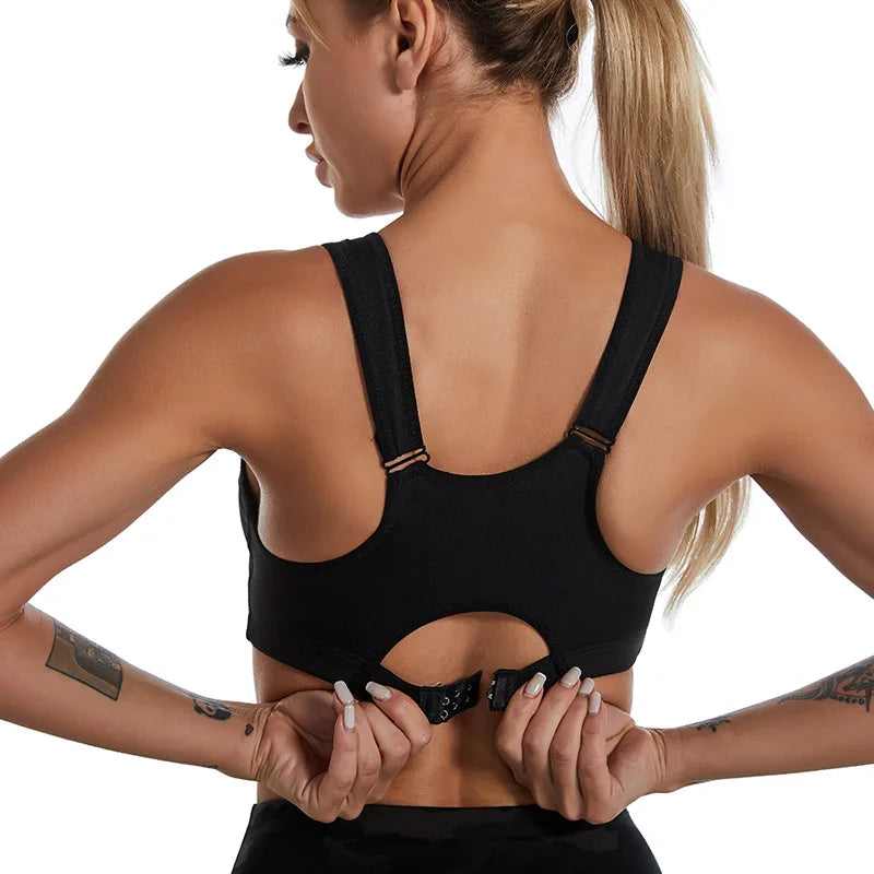 Back view of woman fastening black zipper sports bra for women with adjustable straps
