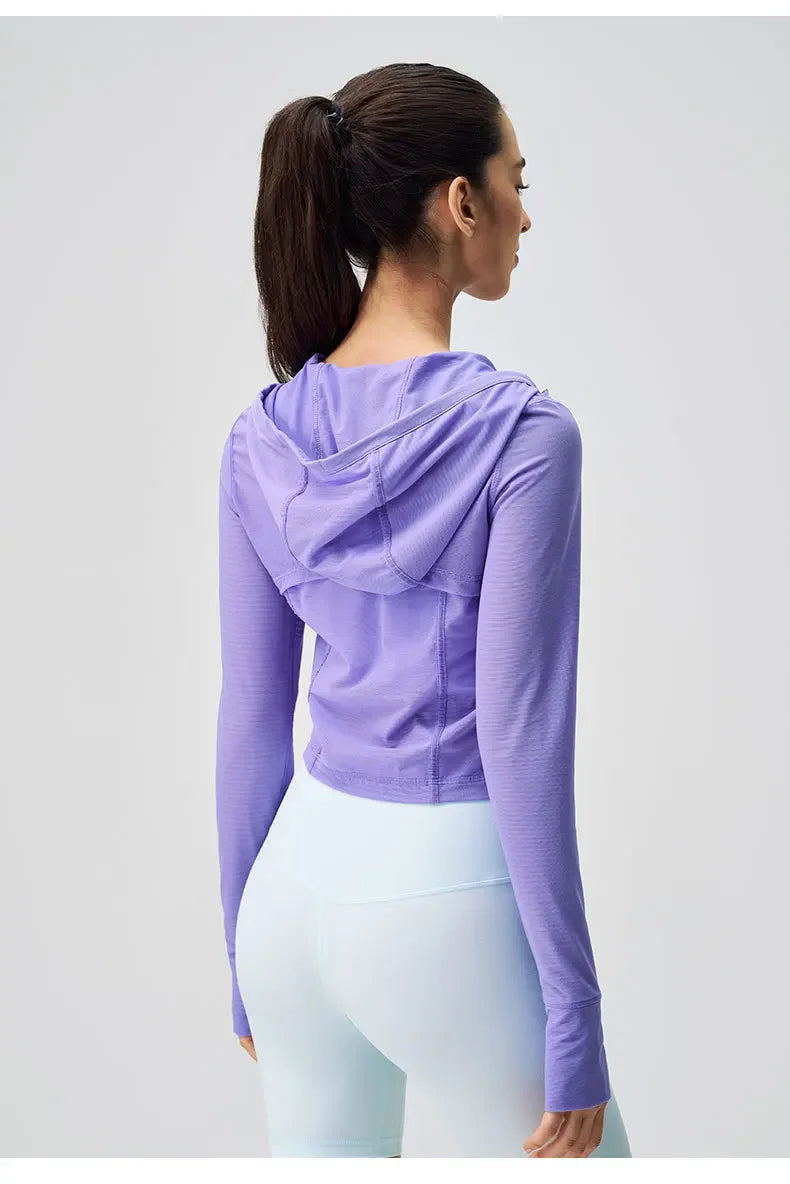 Woman wearing breathable yoga clothes for women by KiKis featuring a lavender hooded top and light blue leggings