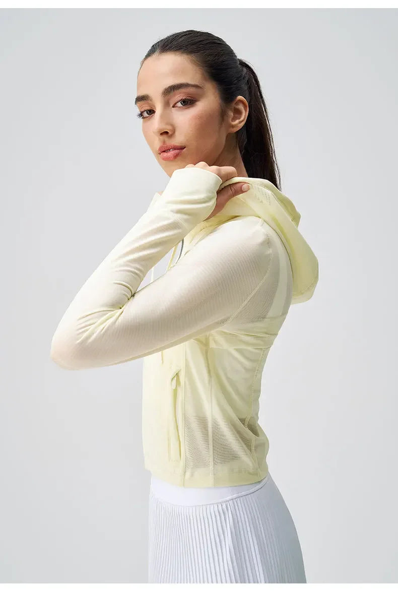 Woman wearing breathable yoga clothes for women KiKis light yellow hooded top with thumb holes