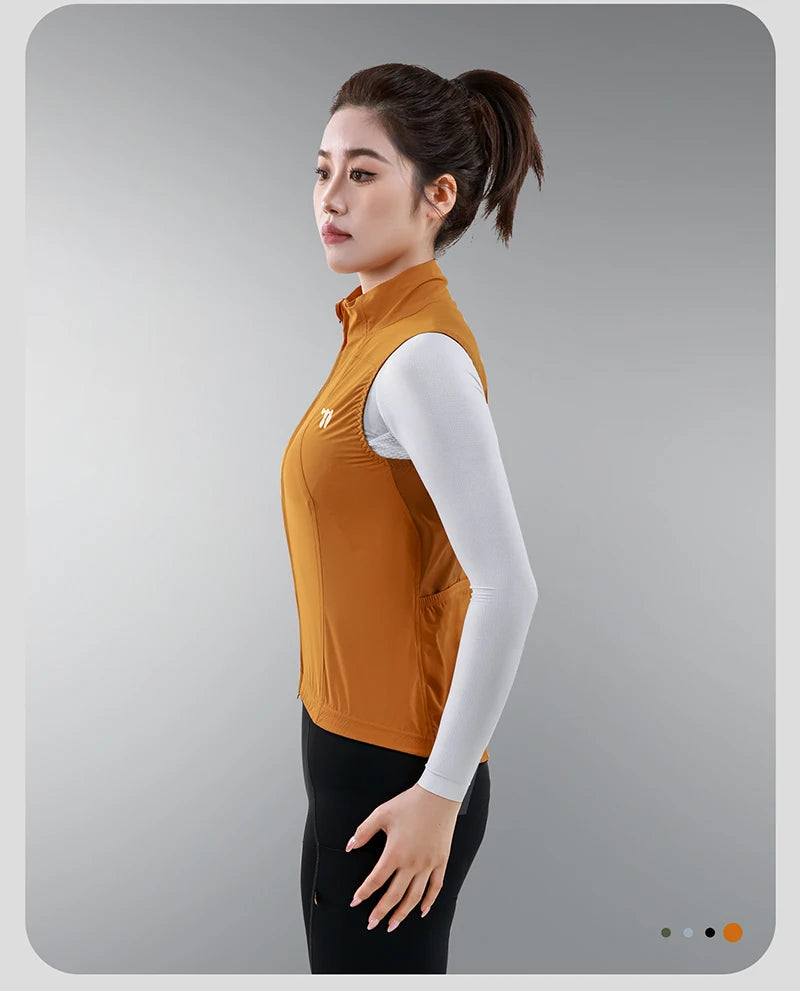 KiKis women's cycling vest summer in orange worn by model with white long sleeve shirt and black pants