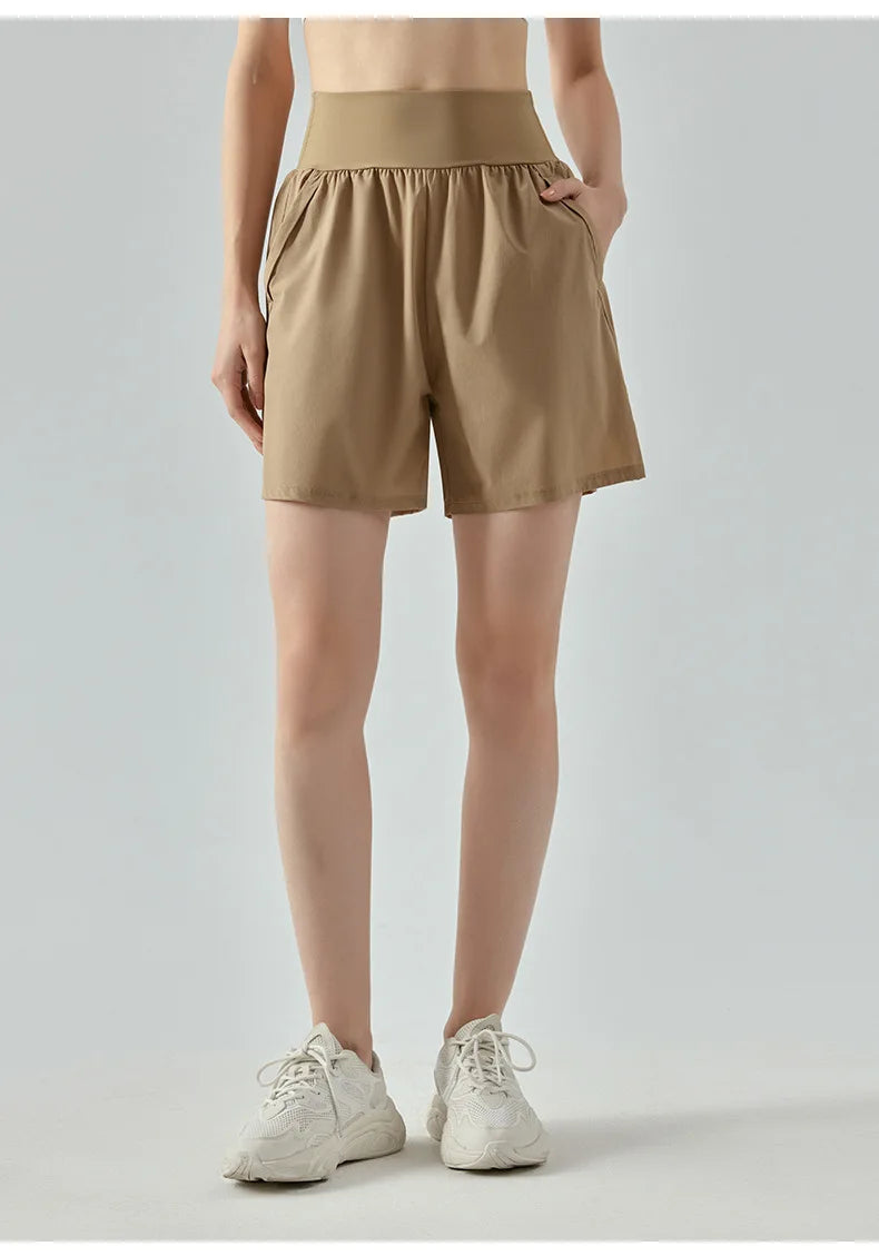 KiKis women's high waist running shorts in beige with elastic waistband and side pockets