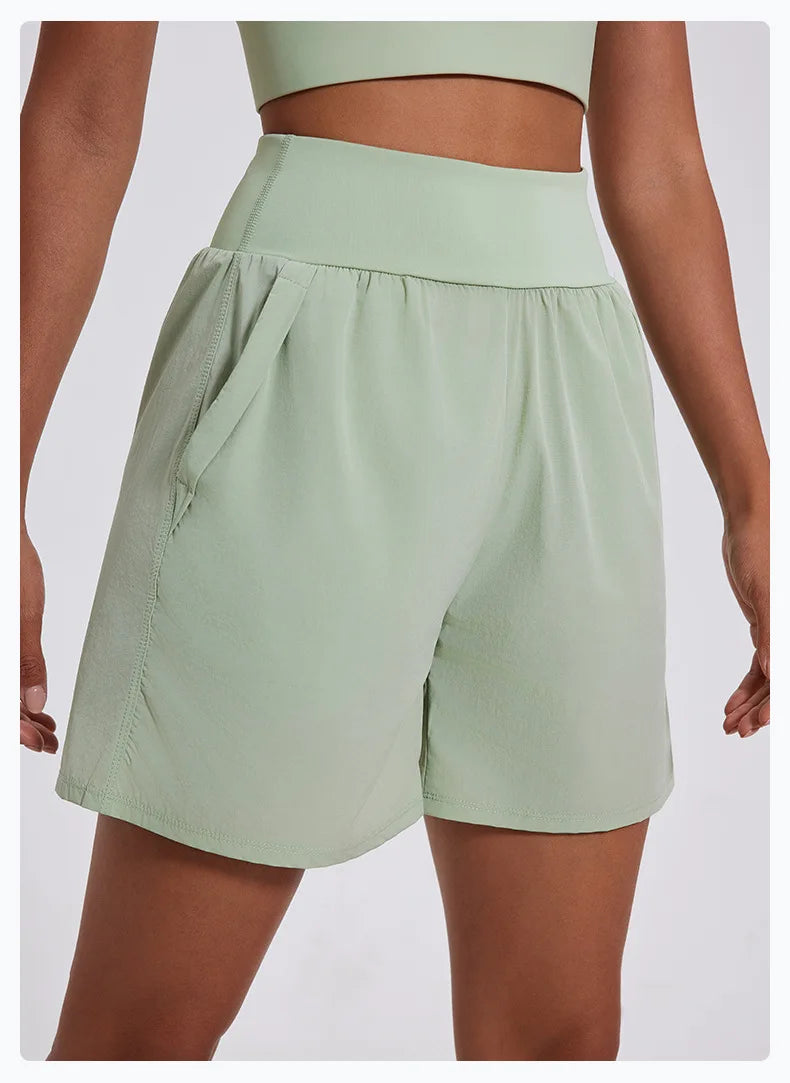 KiKis women's high waist running shorts in light green with side pockets and wide waistband