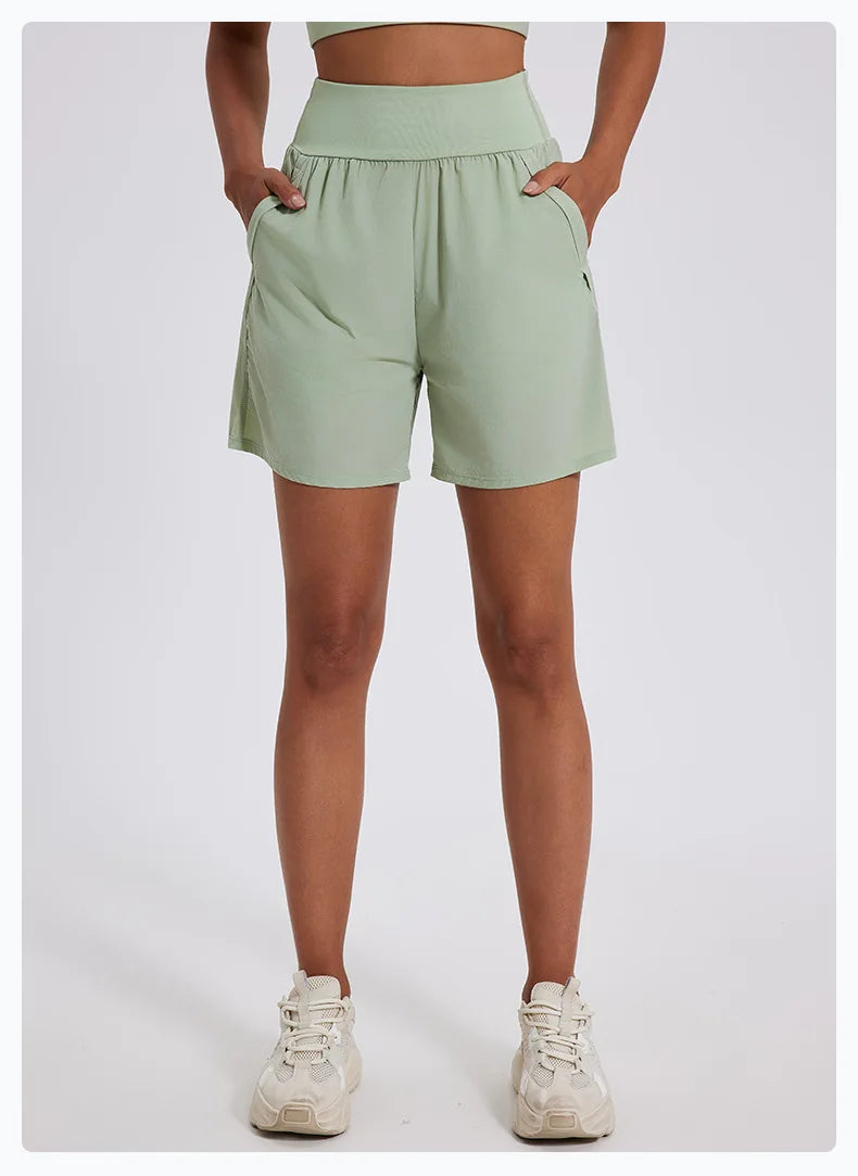 KiKis women's high waist running shorts in light green with pockets and elastic waistband