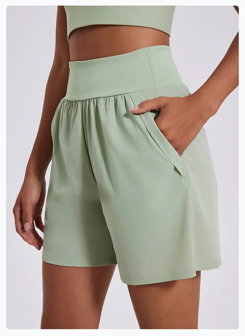 KiKis women's high waist running shorts in light green with front pockets and comfortable fit