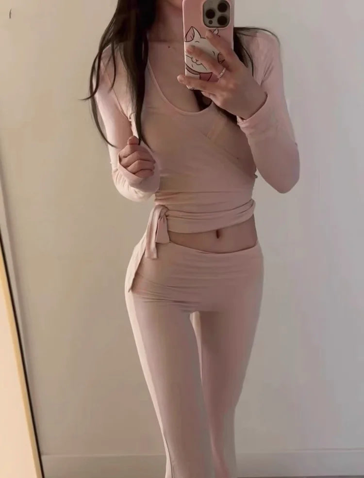 KiKis women's long sleeve yoga top in light pink worn by a woman taking a mirror selfie