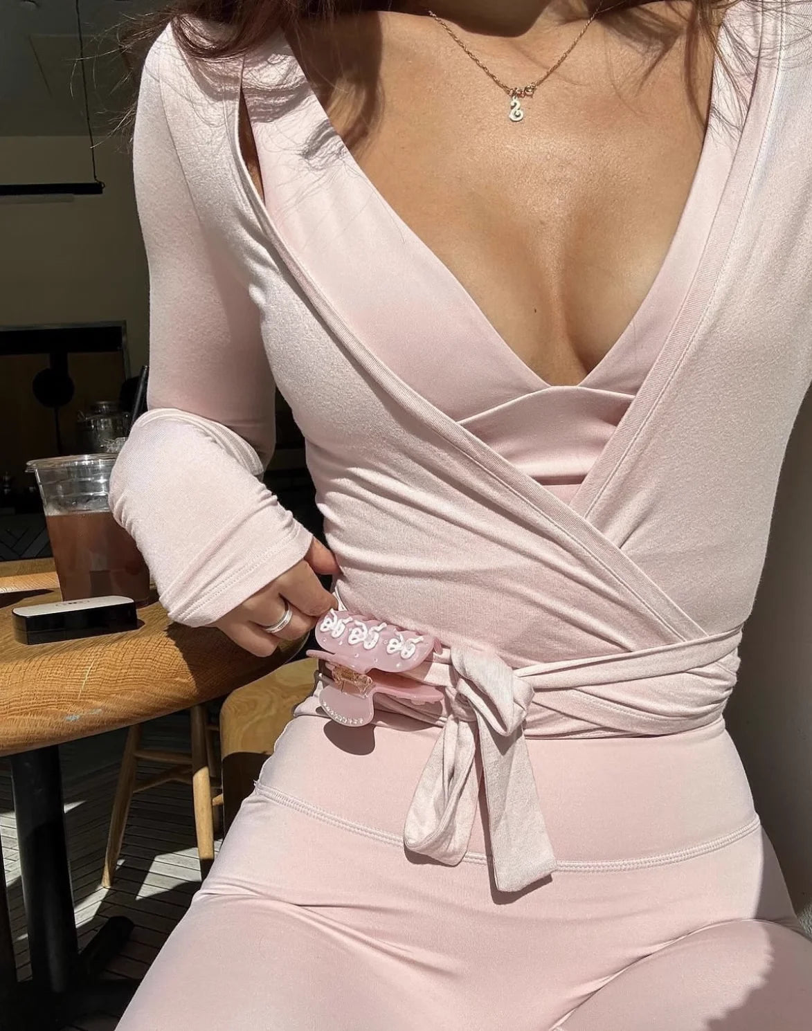 KiKis women's long sleeve yoga top in light pink with wrap design and tie waist detail