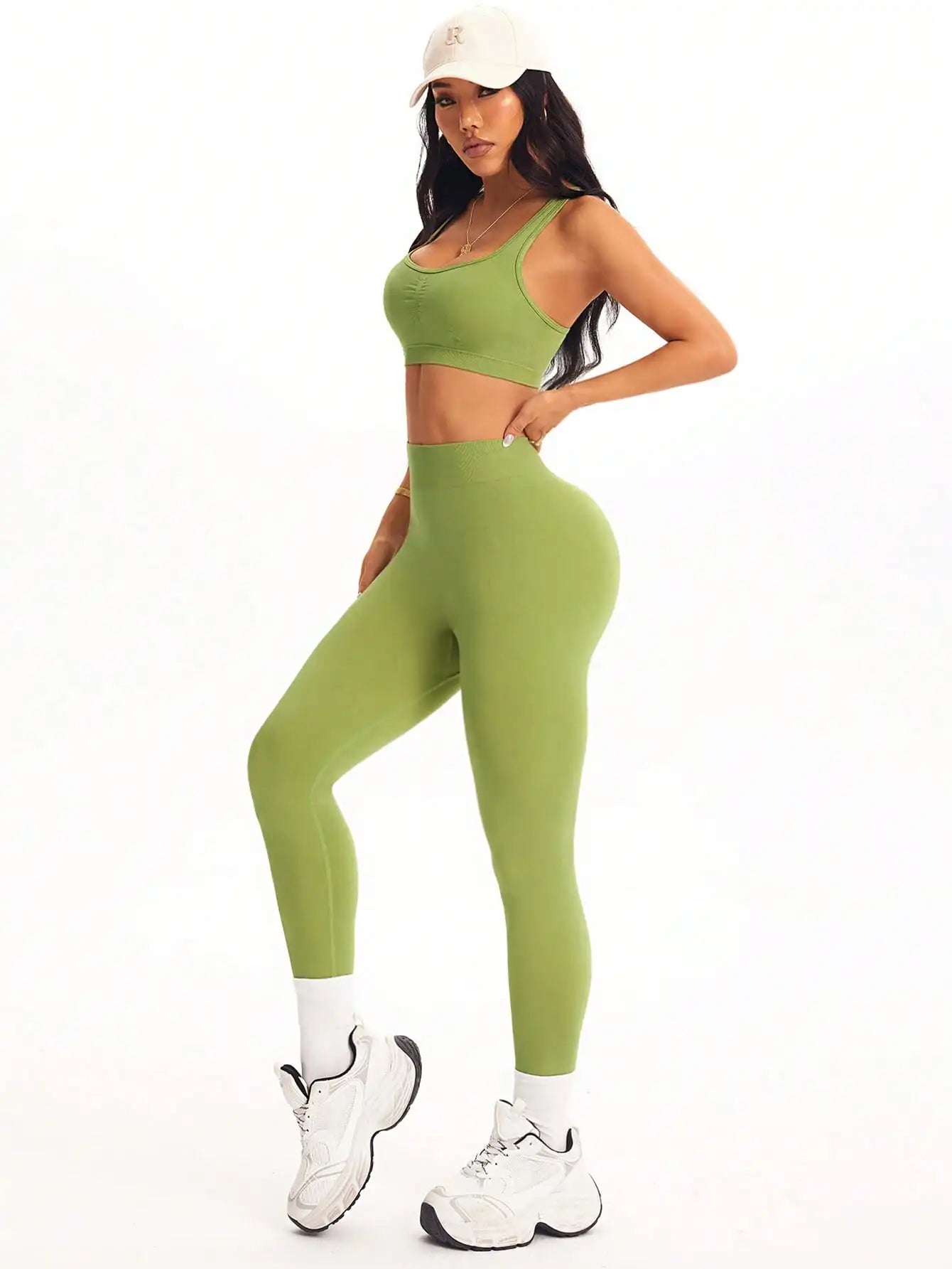 KiKis women's 2 piece yoga set in green worn with white sneakers and a white cap