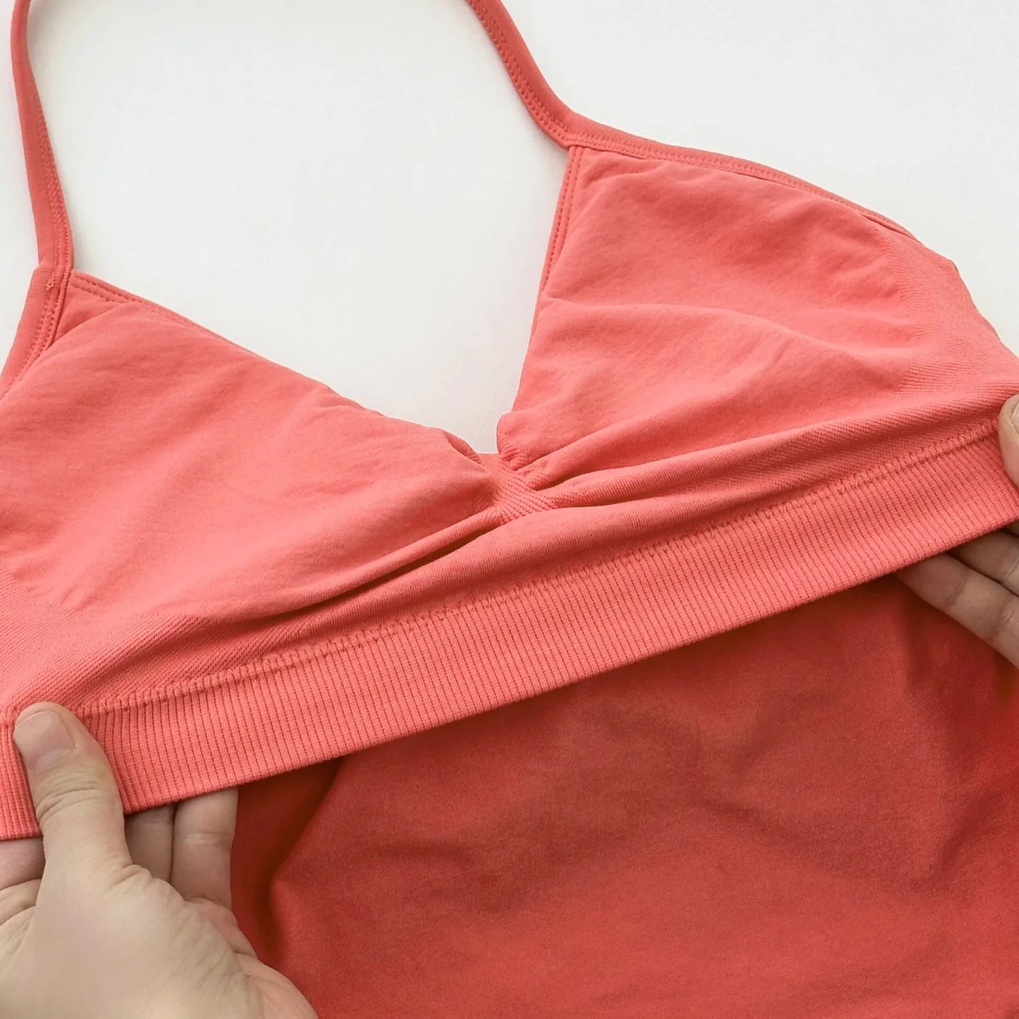 KiKis coral women's backless gym top held to show soft stretch fabric and design details