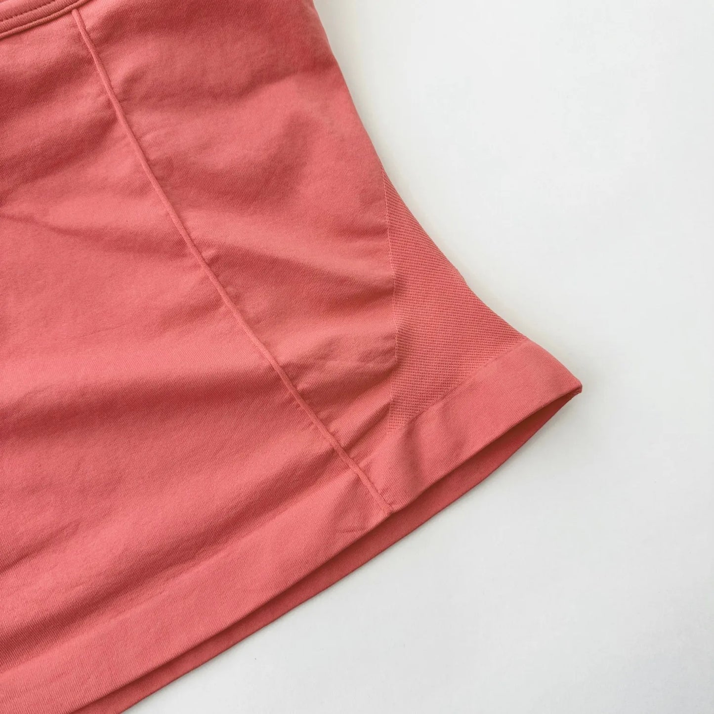 Close-up of coral fabric detail on Women's Backless Gym Top showing seam and texture