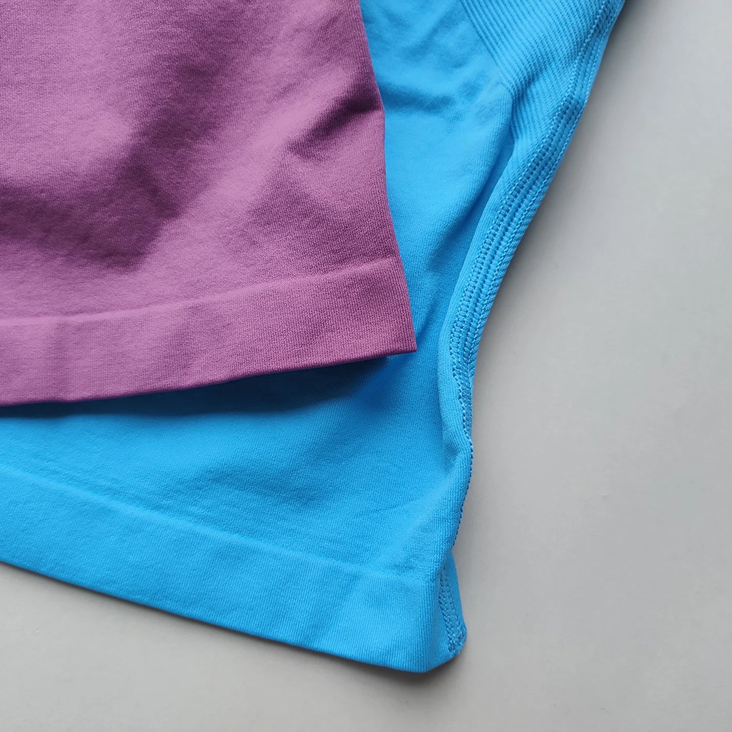 Close-up of folded purple and blue fabric showing the material texture of Women's Backless Gym Top by KiKis