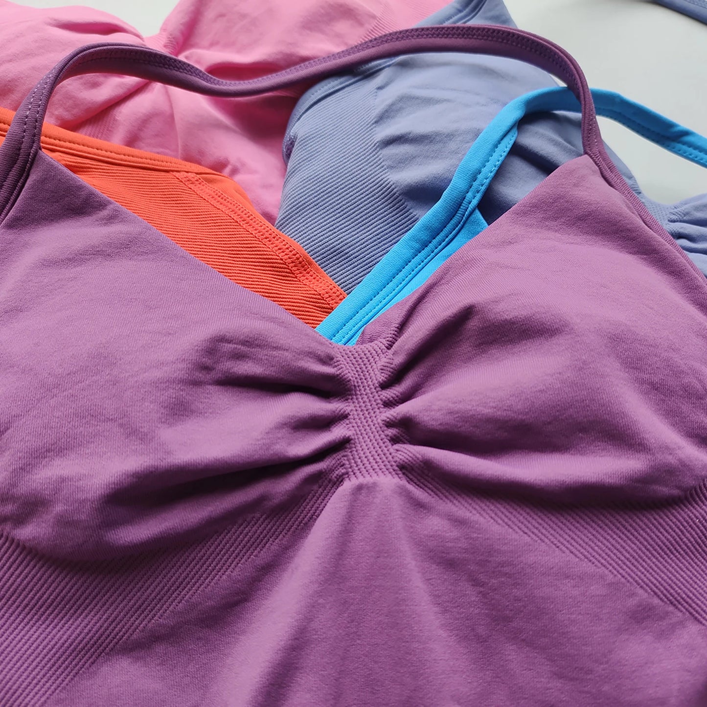 KiKis Women's Backless Gym Top in purple with additional gym tops in pink, orange, blue, and lavender colors