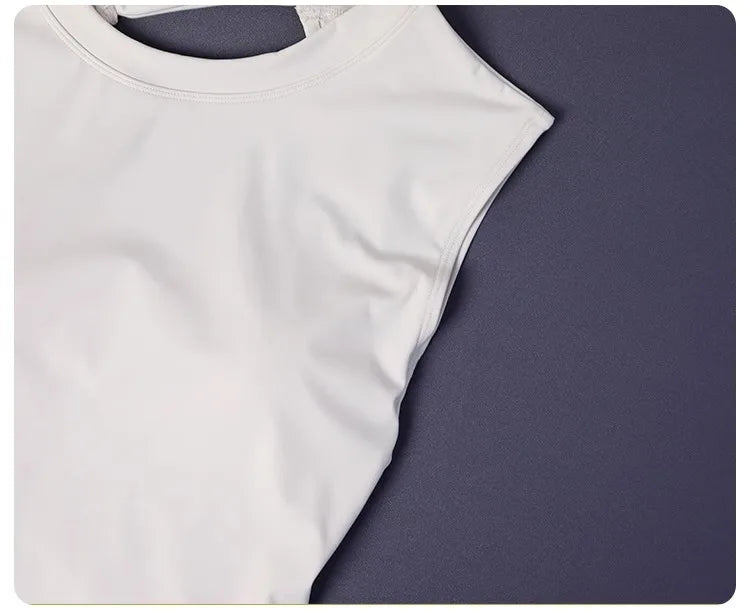 KiKis white women's backless sports tank top made from smooth, lightweight fabric lying flat on dark surface