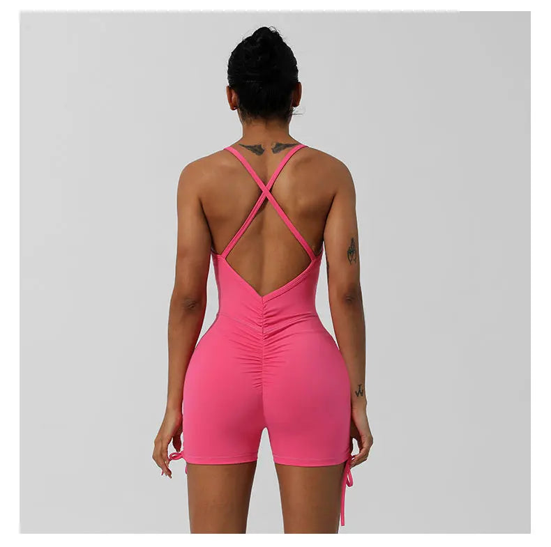 KiKis pink women's cross back yoga jumpsuit with ruched detail and adjustable side ties