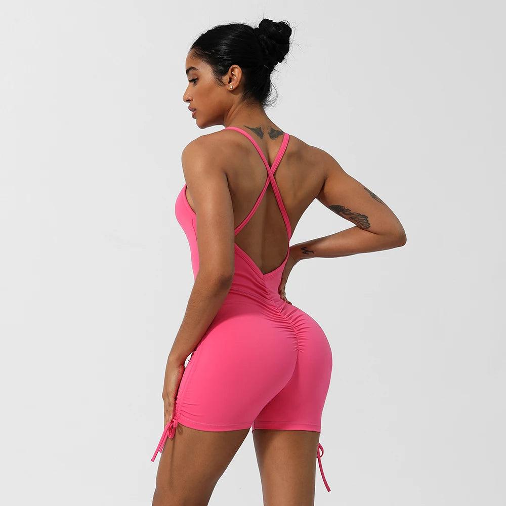 KiKis women's cross back yoga jumpsuit in pink with ruched detailing and adjustable side ties