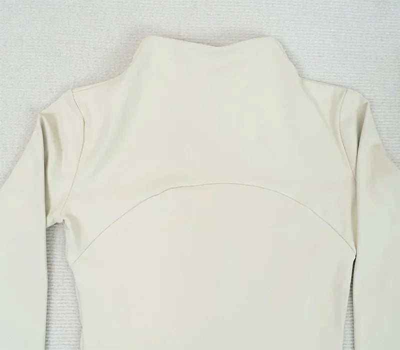 Back view of a light beige women's fleece yoga jacket with long sleeves and a high collar