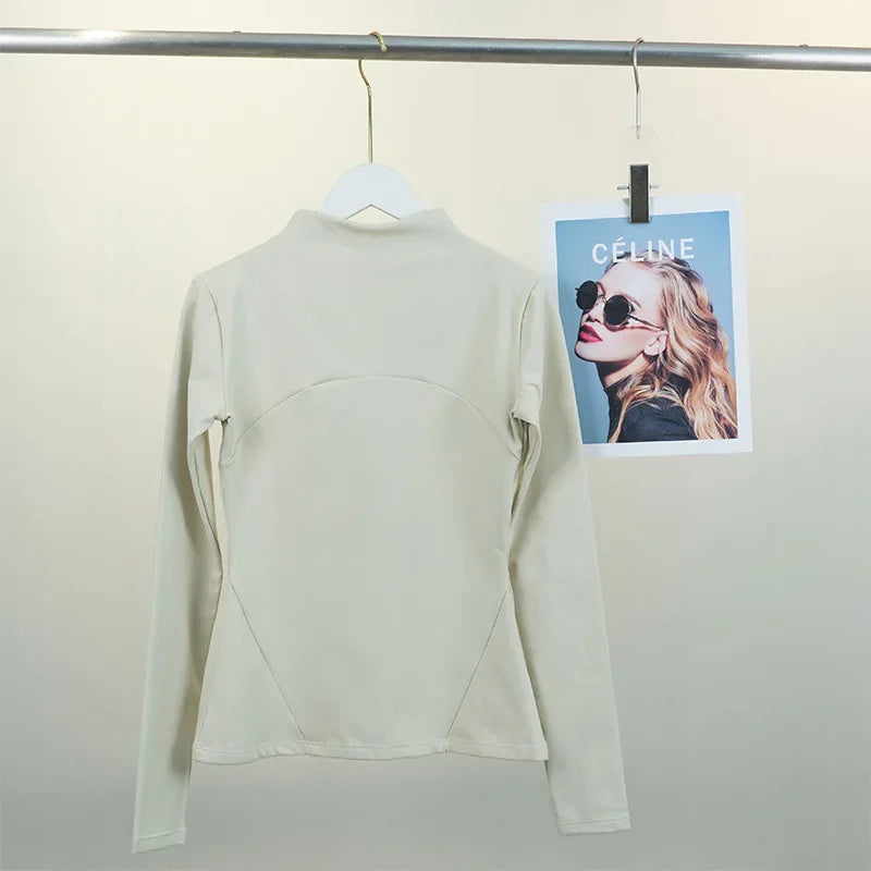 KiKis women's fleece yoga jacket in beige hanging on a white hanger with a fashion photo in the background