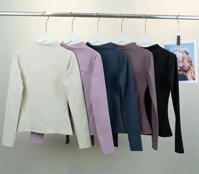 KiKis women's fleece yoga jacket in cream, lavender, navy, mauve, and black hanging on white hangers
