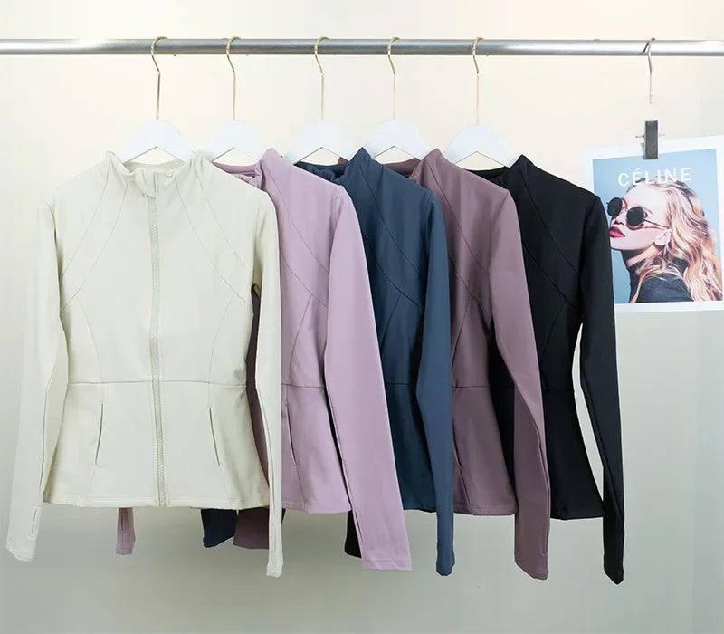 KiKis women's fleece yoga jacket collection in cream, lavender, navy, mauve, and black colors hanging on a rack