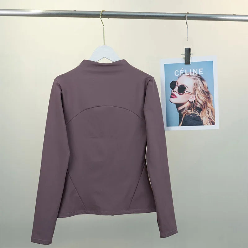 KiKis women's fleece yoga jacket in mauve hanging on a rail showing the back view