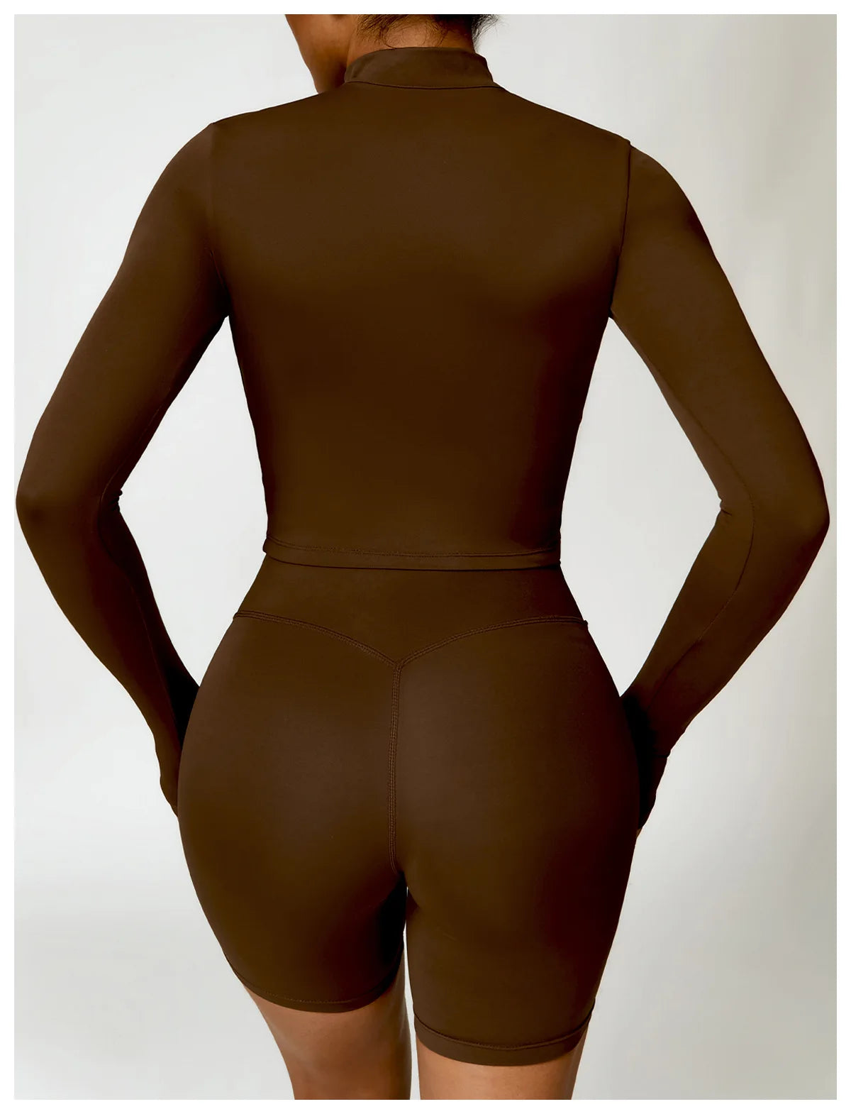Back view of a brown women's gym workout zip up top with long sleeves and fitted design